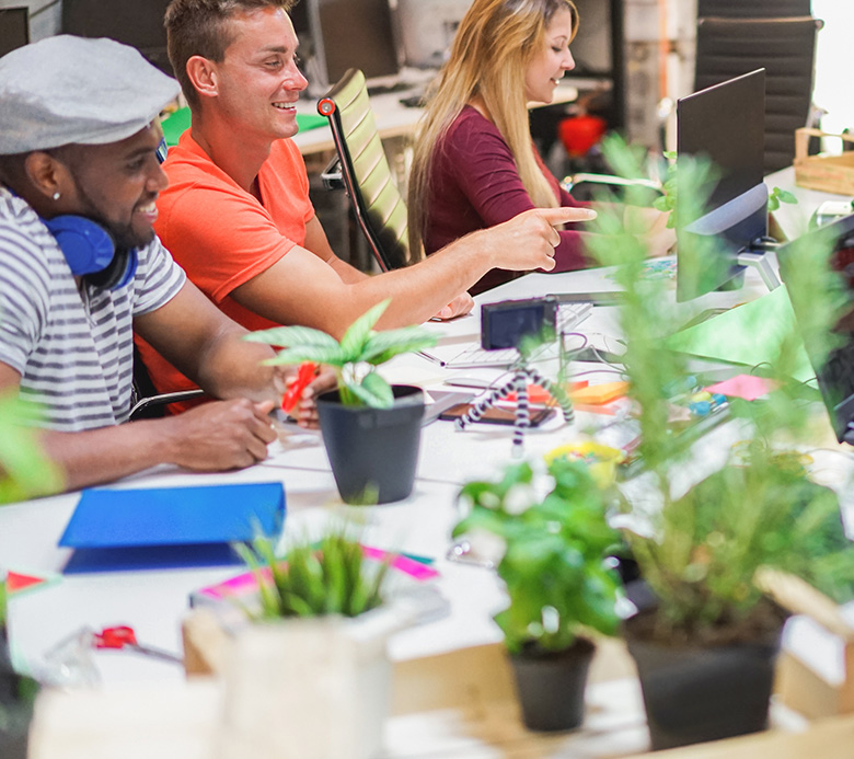 Equipo de jóvenes compañeros hablando durante una startup — Personas felices planificando un nuevo proyecto en una oficina creativa